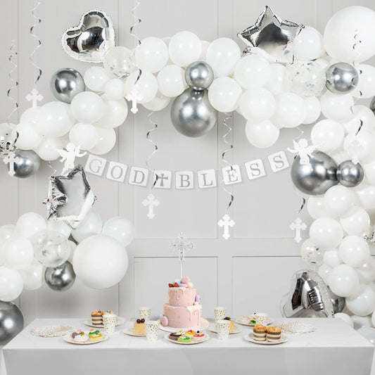 Baptism decorations with white and silver balloons, God Bless banner, cake and desserts table.